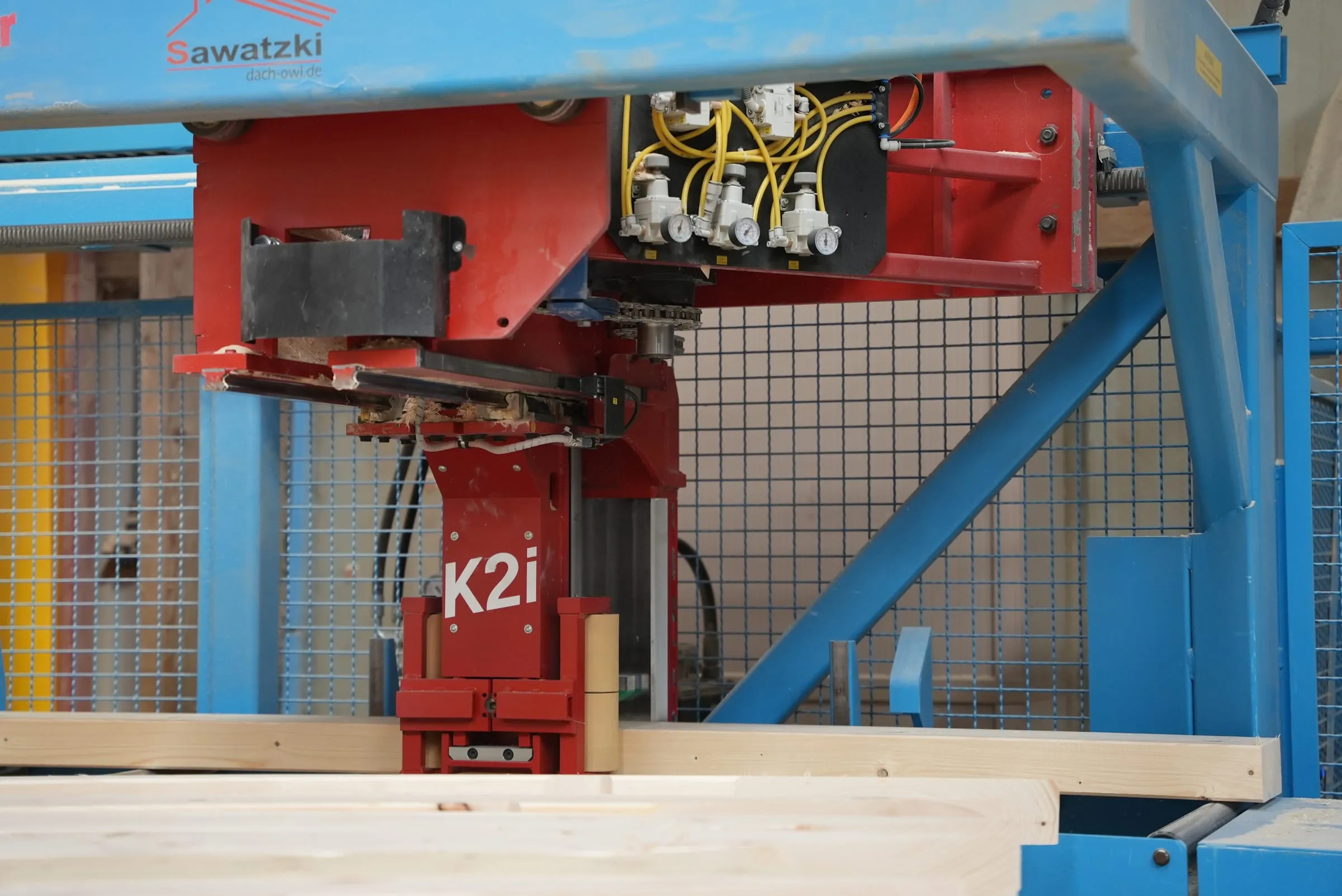 CNC-Abbundanlage K2i bearbeitet einen Holzbalken in der Abbundhalle der Sawatzki GmbH
