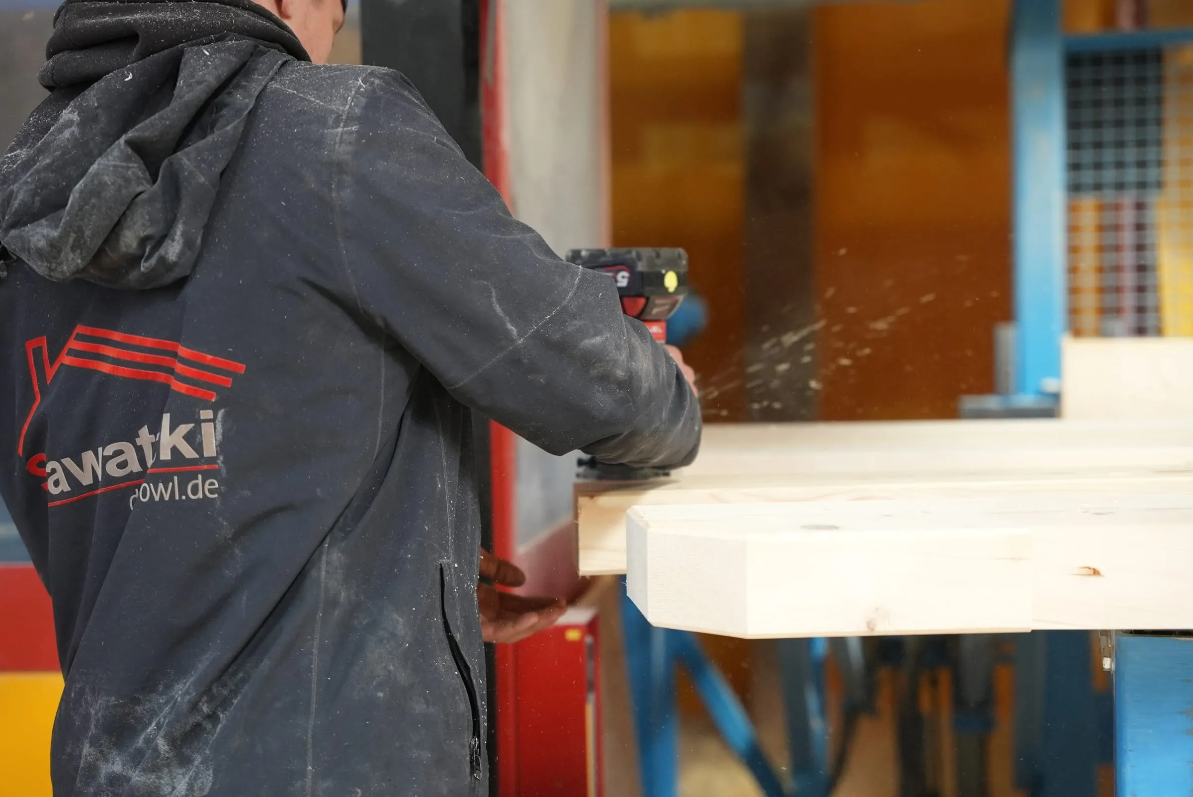Montagebohrung an einem abgebundenen Holzbalken in der Abbundhalle der Sawatzki GmbH