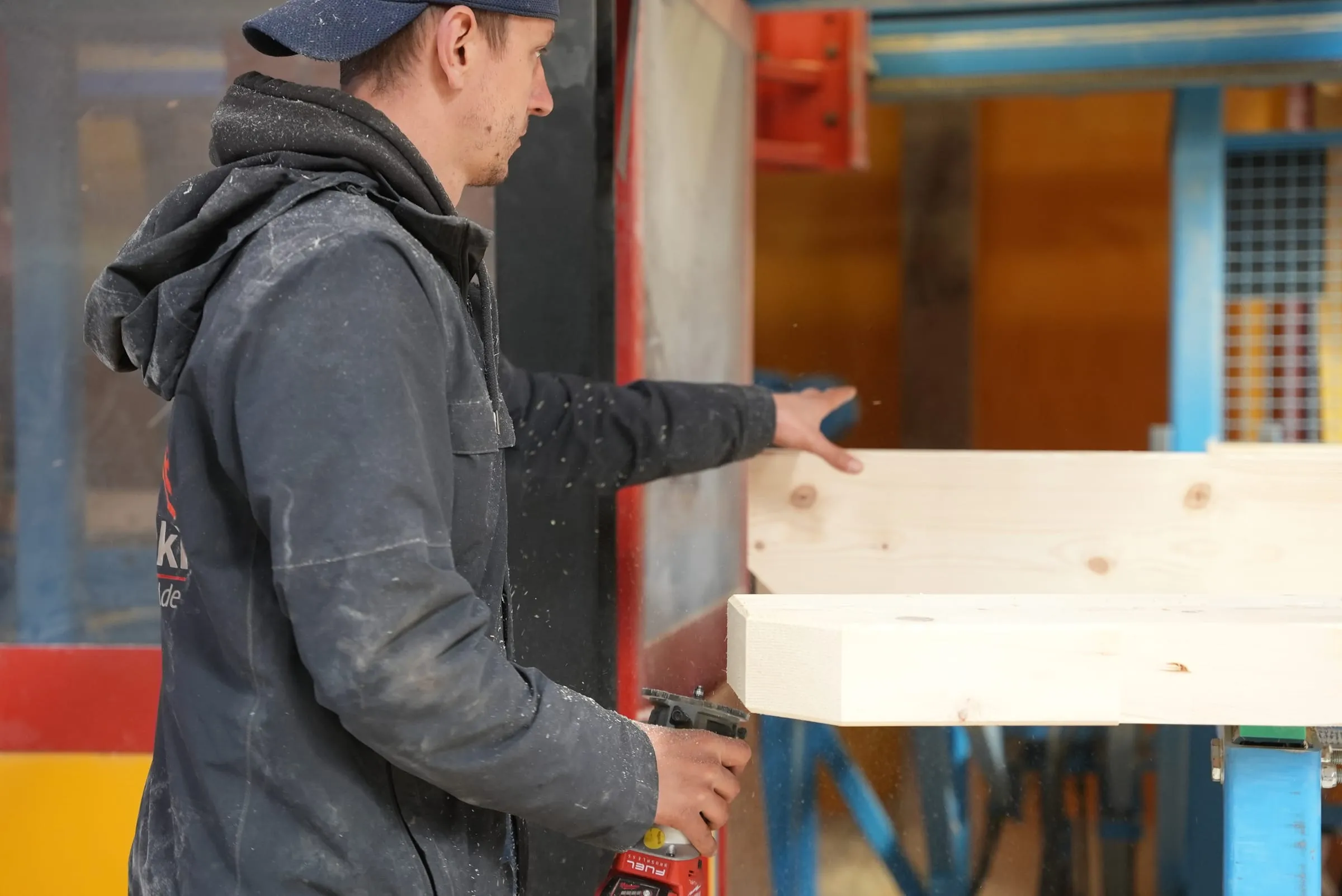 Qualitätskontrolle eines abgebundenen Holzbalkens in der Abbundhalle der Sawatzki GmbH