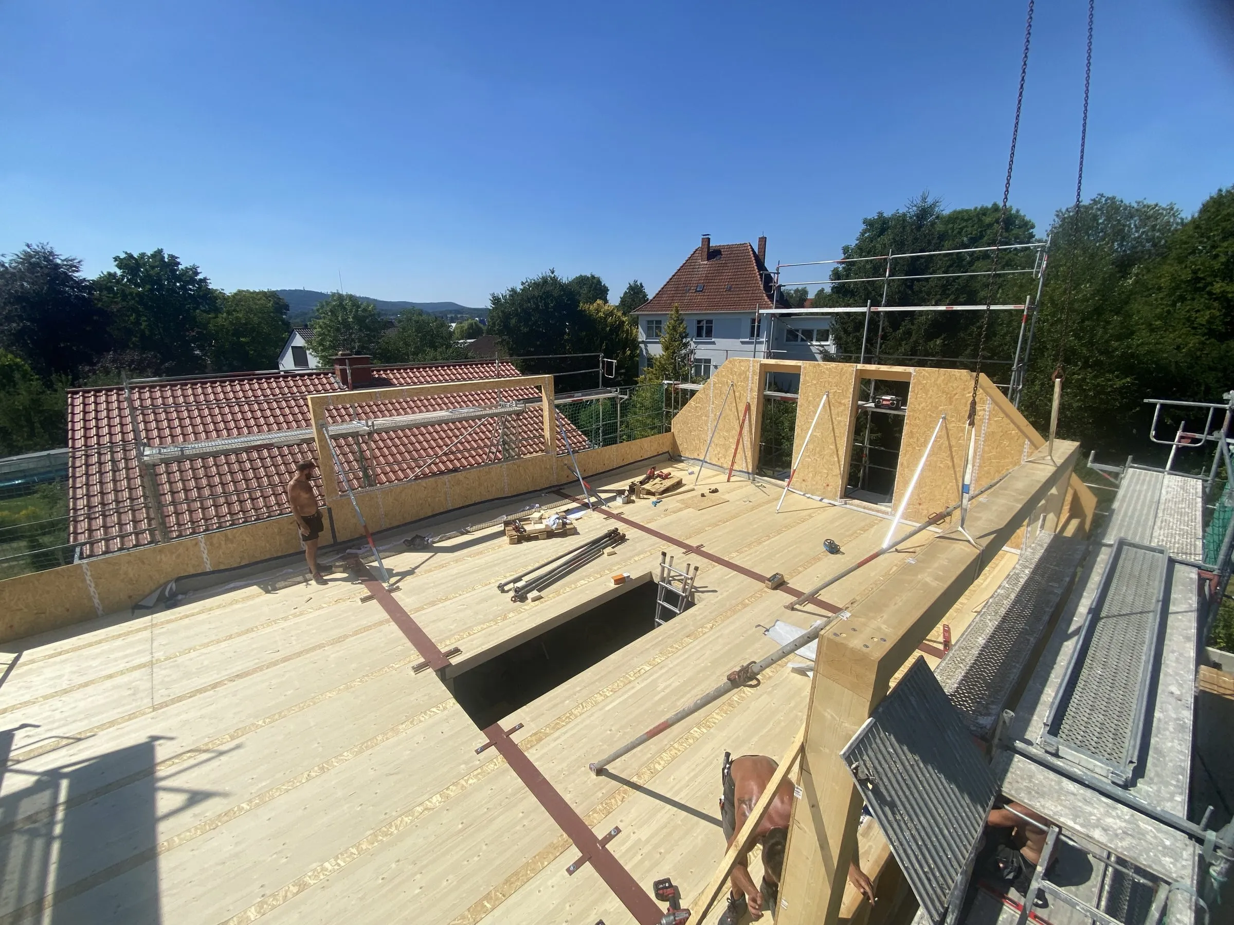 Neue Geschossdecke aus Holzelementen über einem alten Ziegeldach