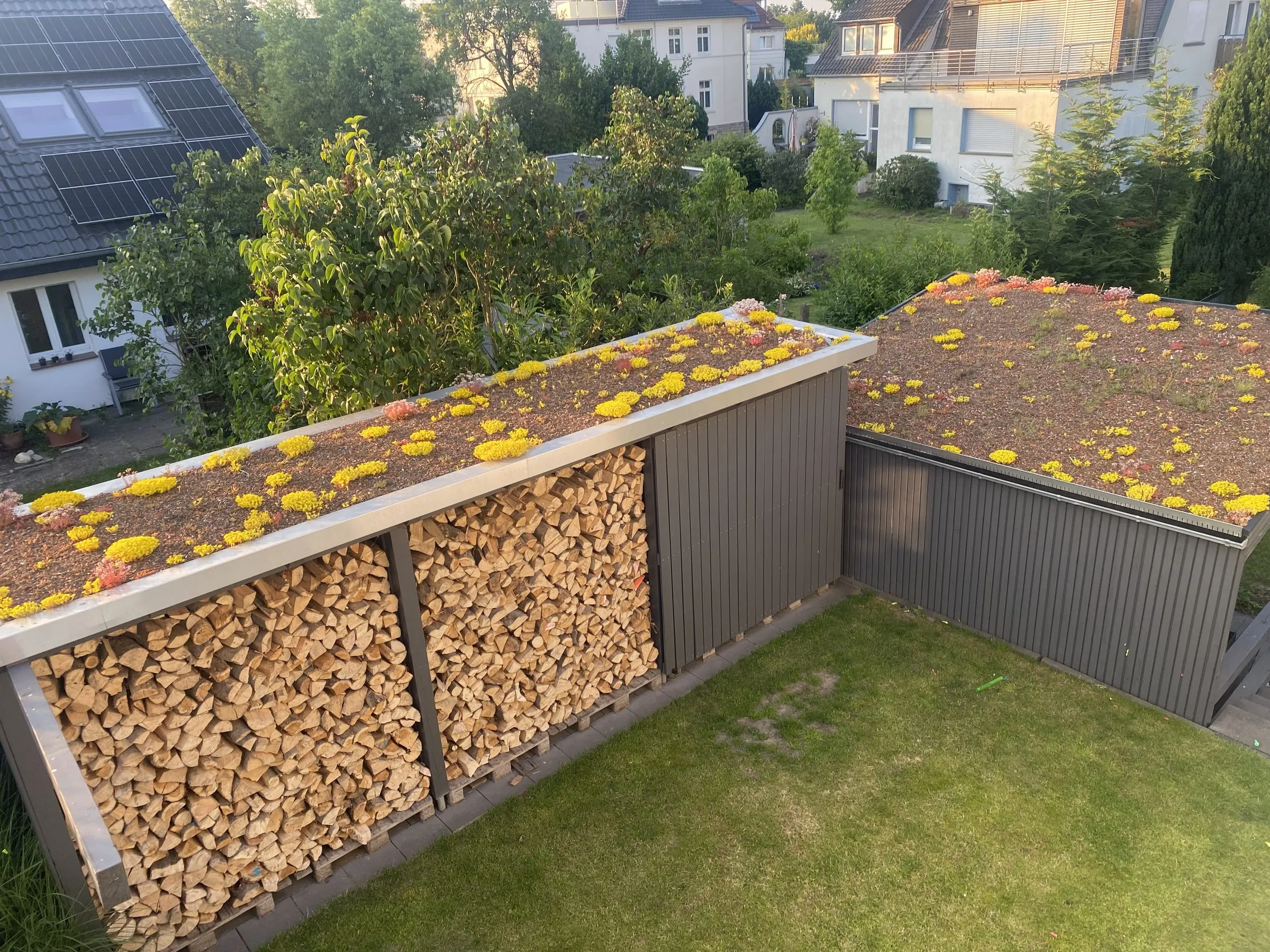 Holzlager mit Blechbekleidung und begrüntem Flachdach