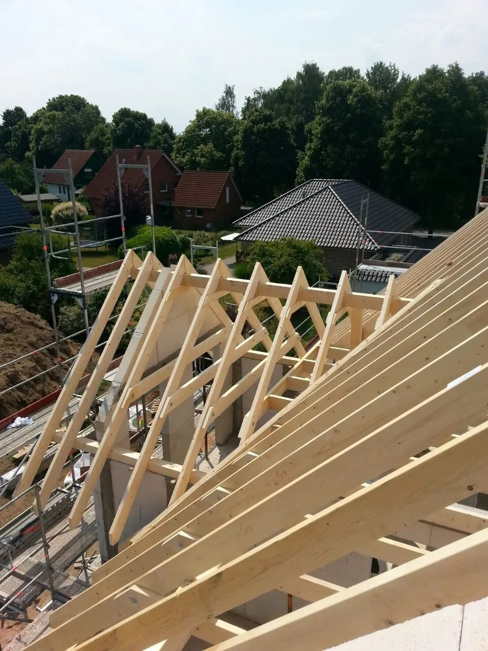 Neue Sparrenlage eines Dachstuhls auf einem eingerüsteten Rohbau in OWL