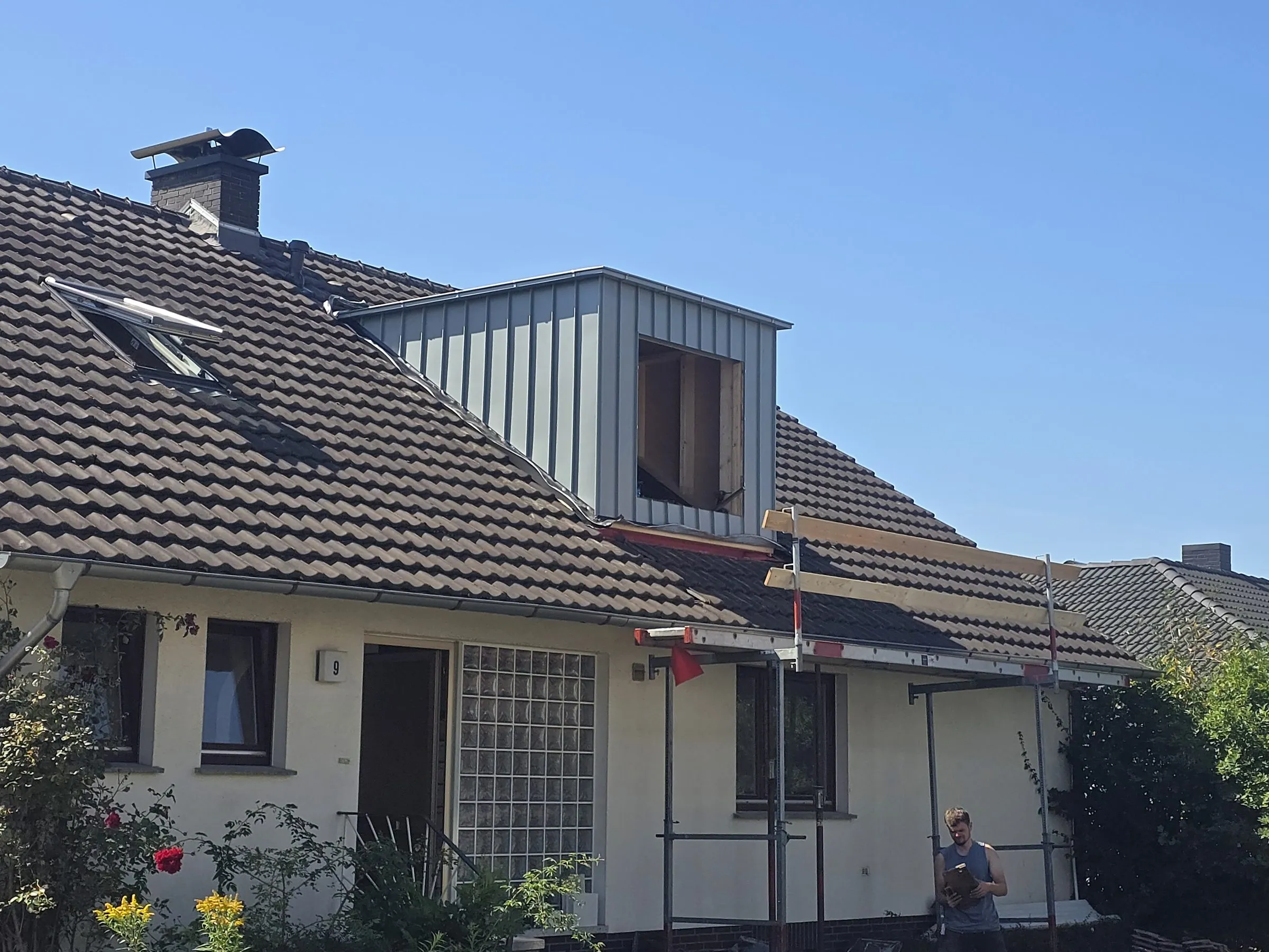 Bestandshaus mit Ziegeldach: neu eingebaute Gaube mit Blechbekleidung, daneben Dachflächenfenster