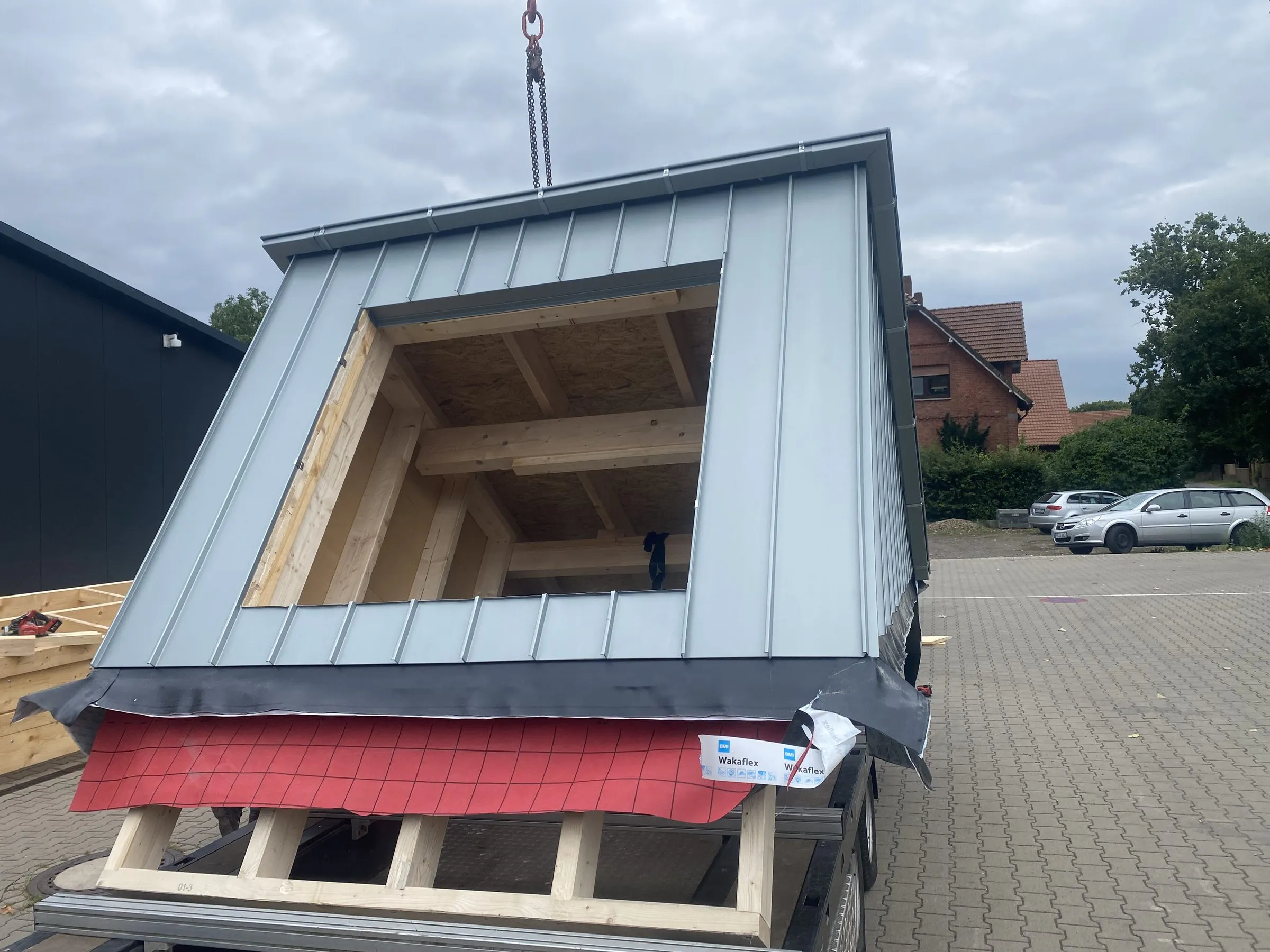 Komplett vorgefertigte Gaube mit Stehfalz-Bekleidung auf dem Tieflader der Sawatzki GmbH, bereit zur Montage