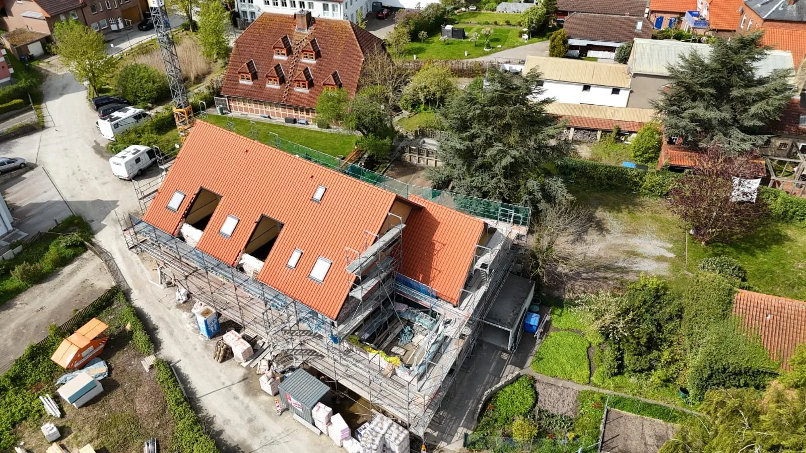 Luftaufnahme eines Wohnhauses in OWL: neu eingedeckte Dachfläche mit eingebauten Dachflächenfenstern und vorbereiteten Öffnungen