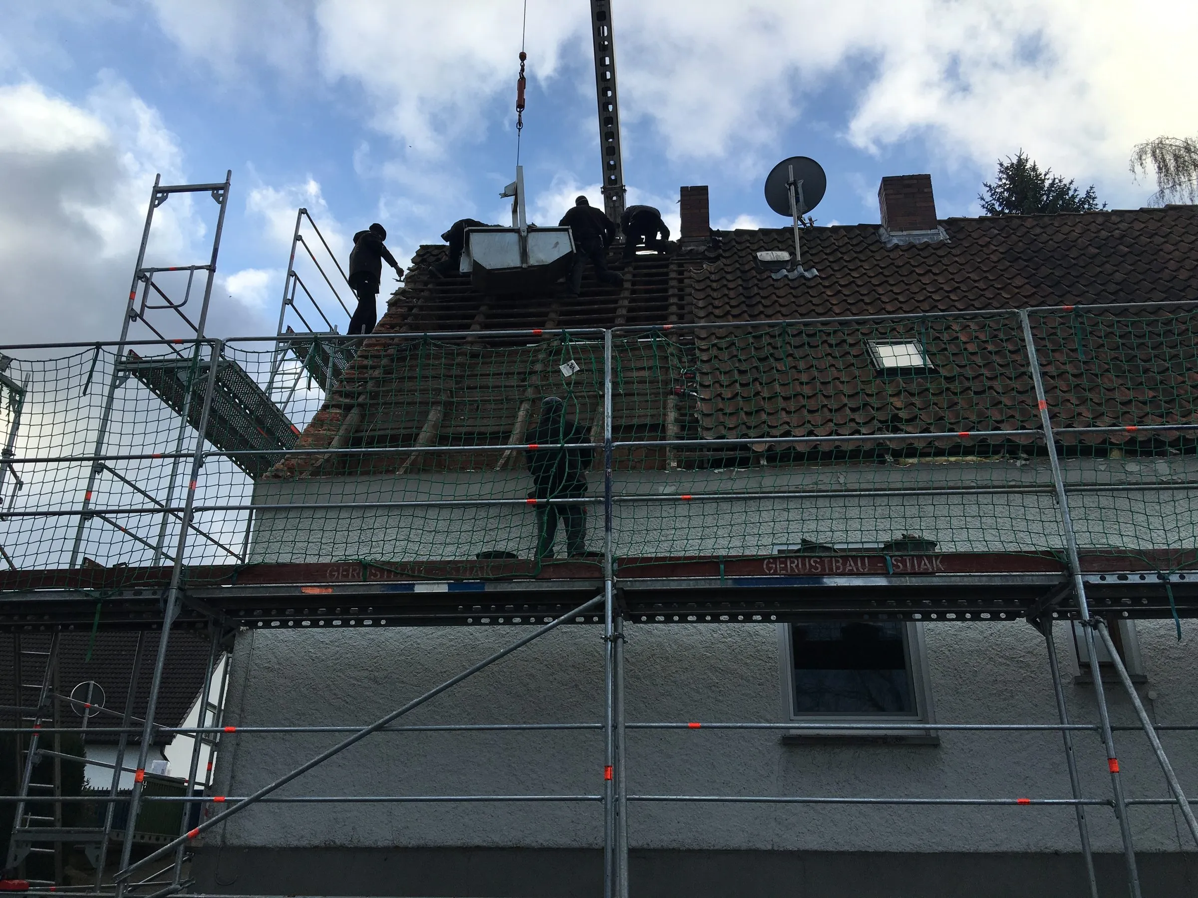 Eingerüstetes Wohnhaus: das Team der Sawatzki GmbH deckt das Bestandsdach für die Sanierung ab