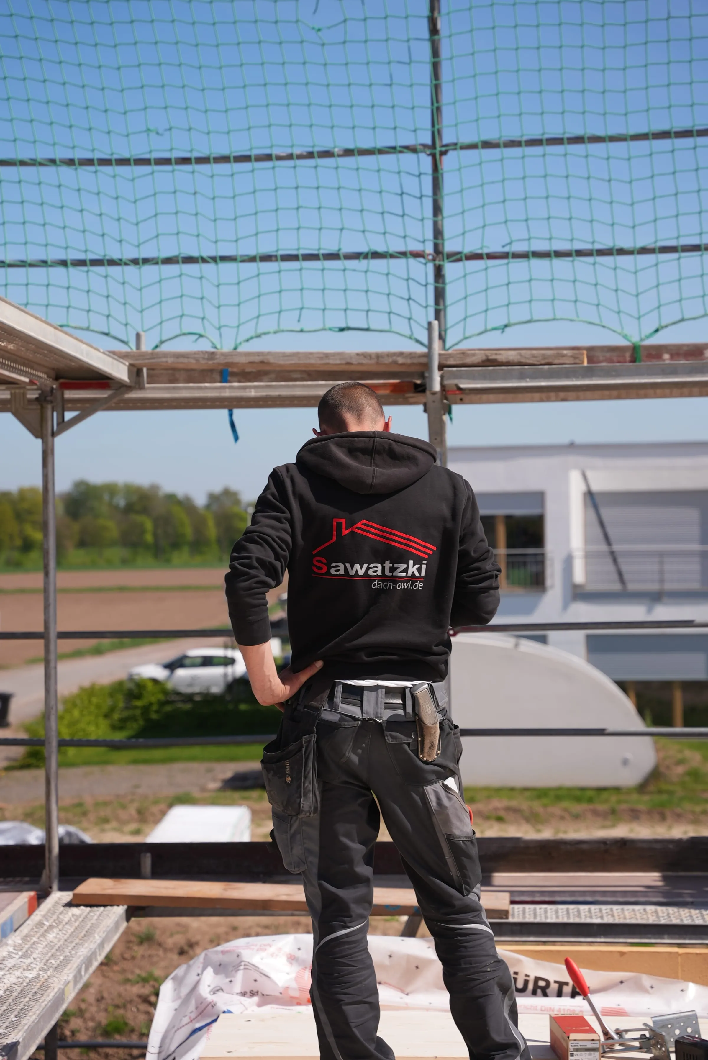 Zwei Mitarbeiter der Sawatzki GmbH verschaffen sich einen Überblick über eine Dachbaustelle in Ostwestfalen-Lippe