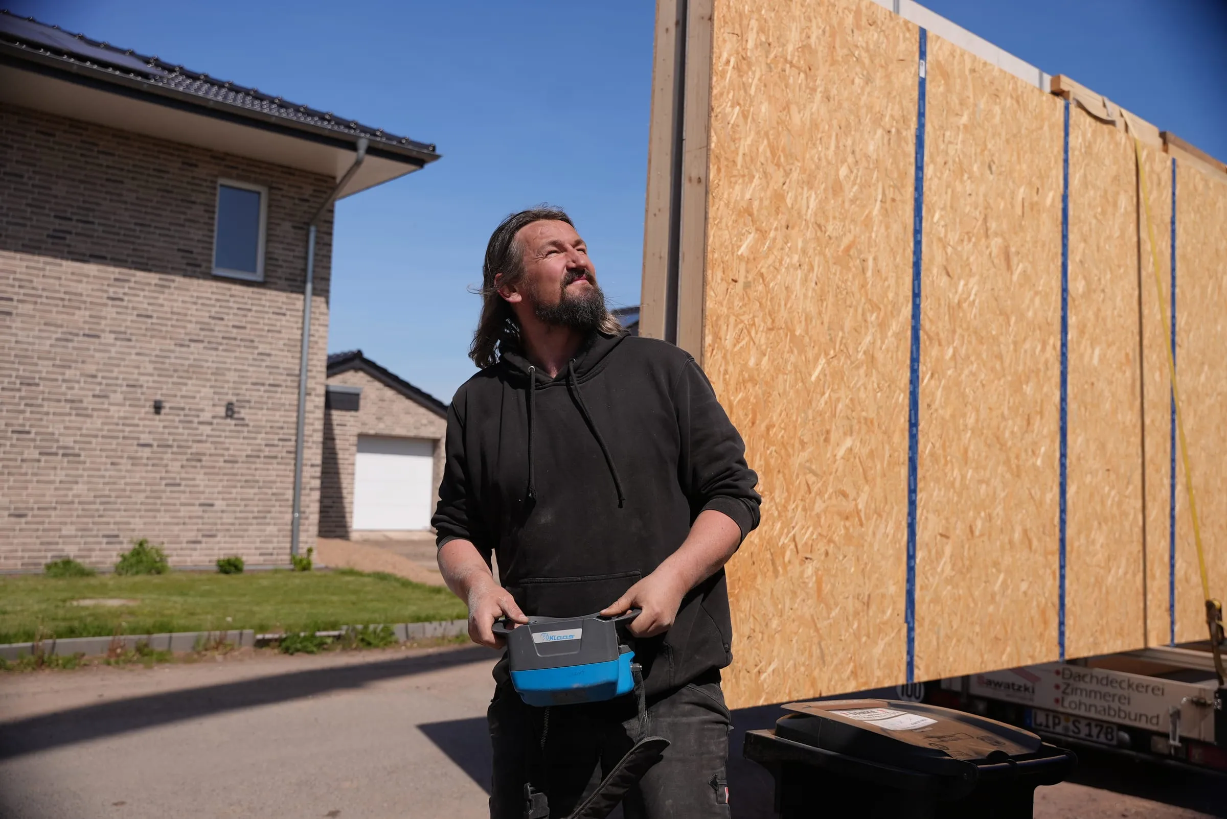 Zimmerer der Sawatzki GmbH richten ein Wandelement aus Holz aus